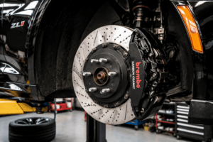showing a detailed performance brake setup on an American sports car, highlighting track-focused upgrades and mechanical details